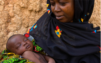 Woman holds a child. © Arne Hoel / World Bank