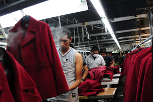 Men assemble women’s coats in a maquila manufacturing factory in Chimaltenango, Guatemala. © Maria Fleischmann / World Bank
