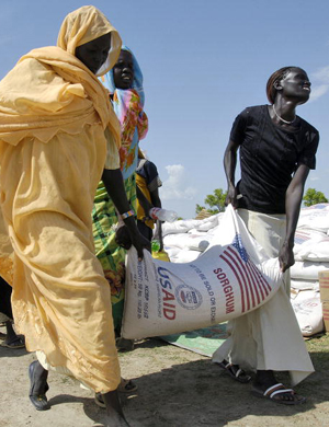 Women carry their ration of food. © UN Photo/Tim Mc Kulka